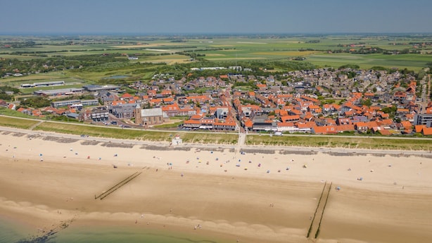 An aerial view of a coastal town with a beach, houses, and a church. - Apartment in Zoutelande Near Sunny Beach (Zoutelande)