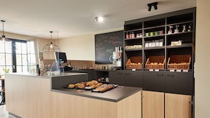 Ein modernes Café mit Holztresen, einer Kreidetafel mit der Speisekarte und Regalen voller Gebäck.