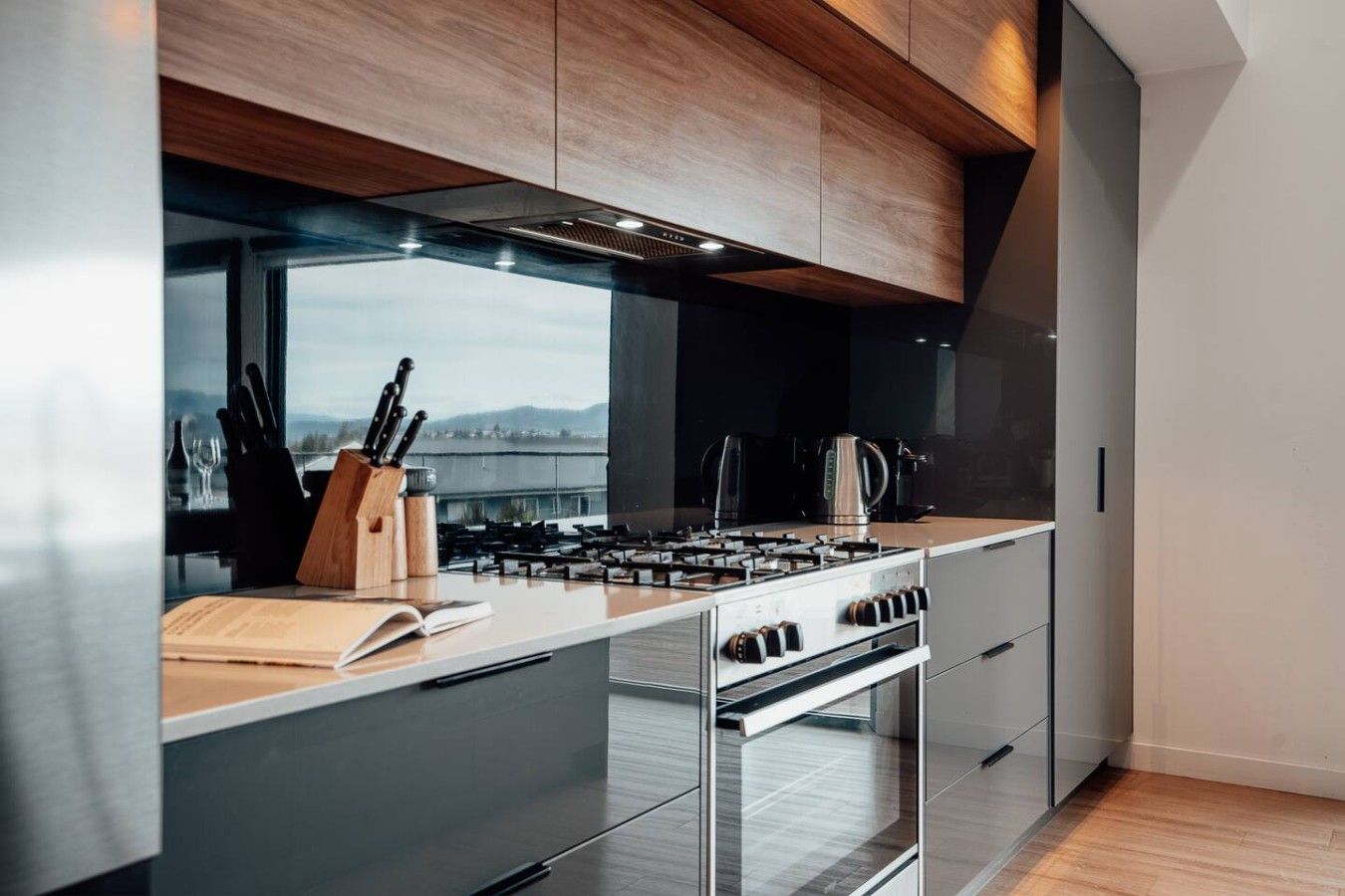 Une cuisine moderne équipée d’une cuisinière à gaz, d  ’un four et offrant une vue sur l’extérieur.