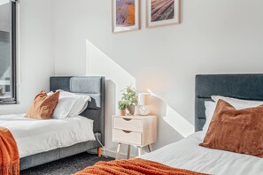 A hotel room with two beds, a bedside table with a lamp, and a window. - Sorell Hobart 4 Bedroom Family Retreat Near Airport (Sorell)
