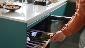 A person opening a wine refrigerator in a kitchen. - Holiday Home in Drents-friese Wold With Sauna (Appelscha)