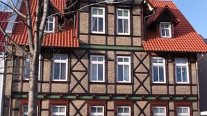 A multi-story building with a traditional half-timbered facade, red-tiled roofs, and multiple windows. - Harz Enjoyment Modern Retreat (Wernigerode)