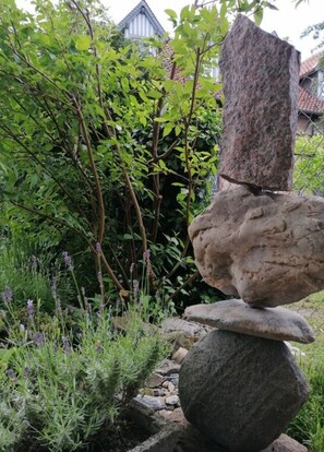 A garden with a stone stack and a variety of plants. - Harz Enjoyment Modern Retreat (Wernigerode)