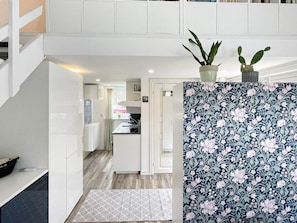 A modern kitchen with white cabinetry, a patterned backsplash, and a small potted plant on the counter. - 4 Star Holiday Home in Rockneby (Rockneby)