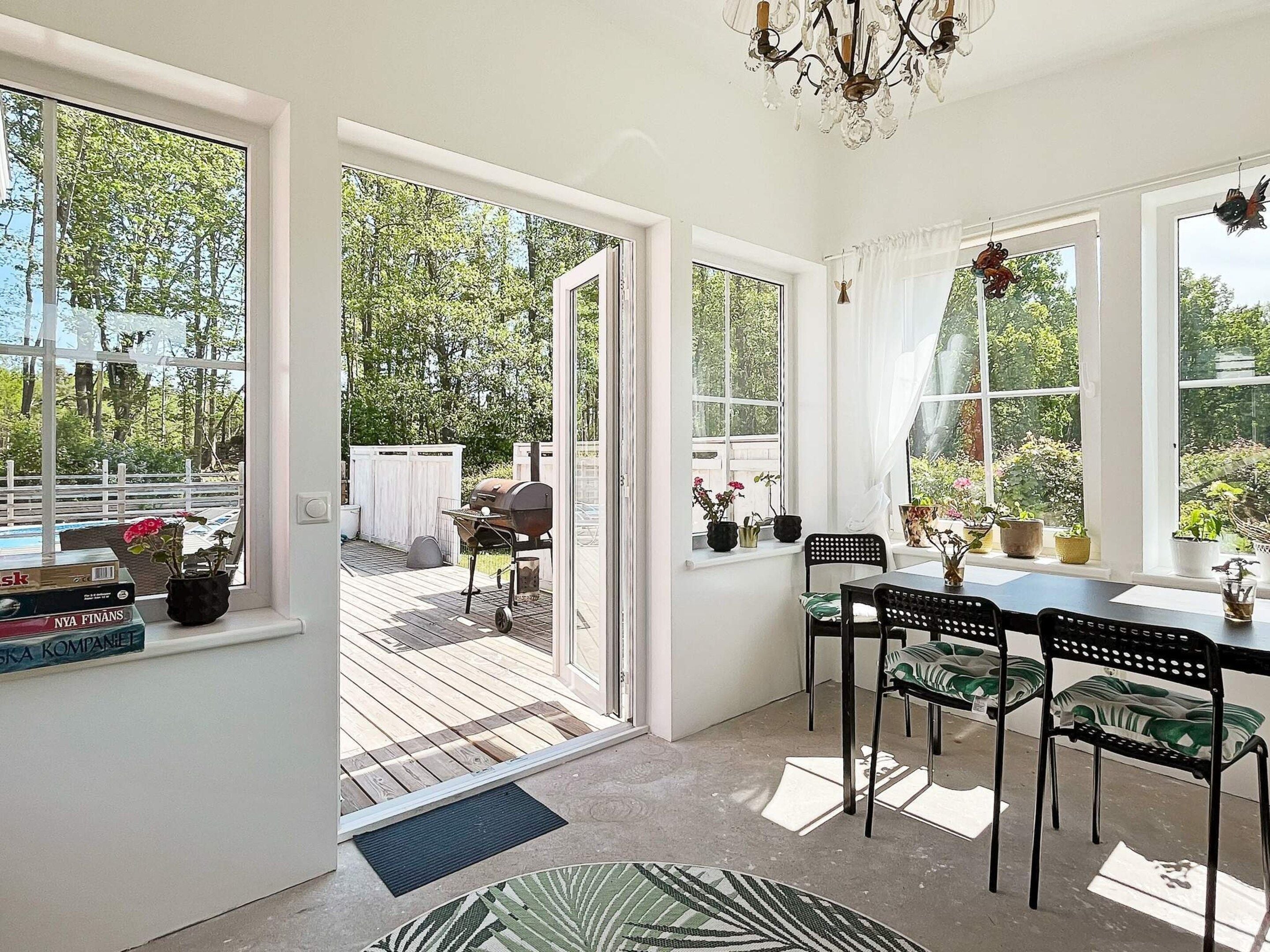A room with a dining area, a view of the outdoors, and a sliding glass door leading to a patio.