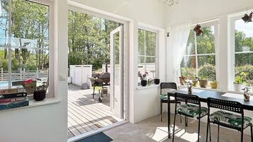 A room with a dining area, a view of the outdoors, and a sliding glass door leading to a patio.