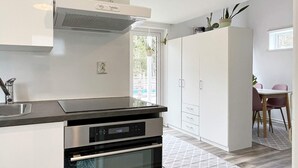 A modern kitchen with a built-in oven, a stainless steel range hood, and a white cabinet with a handle. - 4 Star Holiday Home in Rockneby (Rockneby)