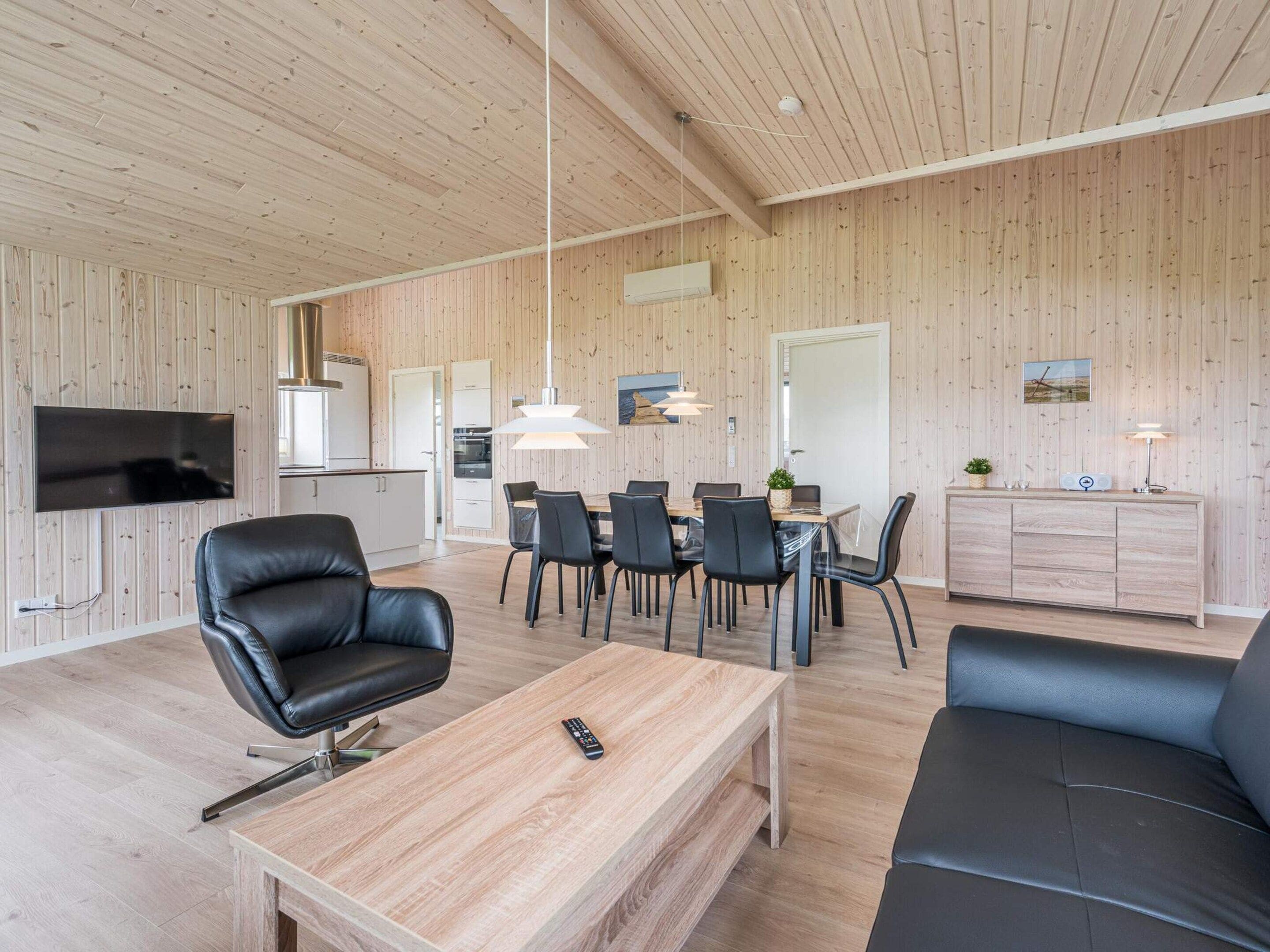 A modern living space with a wooden interior, a dining area, and a seating area.