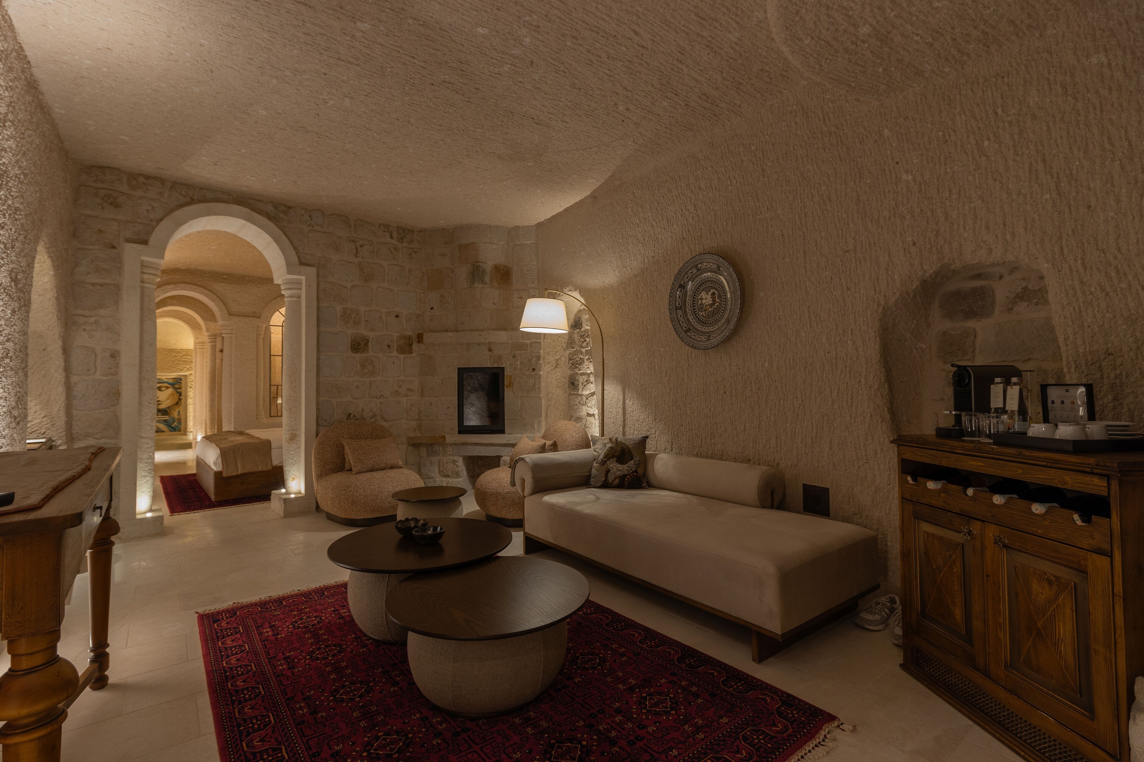 Un salon chaleureux avec des murs en pierre, un canapé, une table basse et une cheminée.