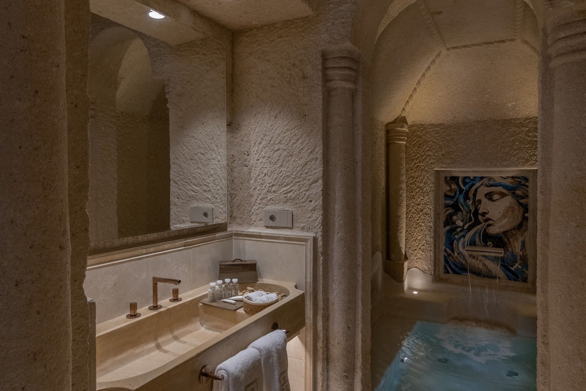 A luxurious bathroom with a large bathtub, a double sink, and a mirror.