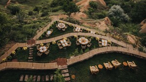 A resort with a central courtyard featuring outdoor seating, surrounded by rocky terrain and unique rock formations. - Via Regia Hotel Cappadocia (Nevsehir)
