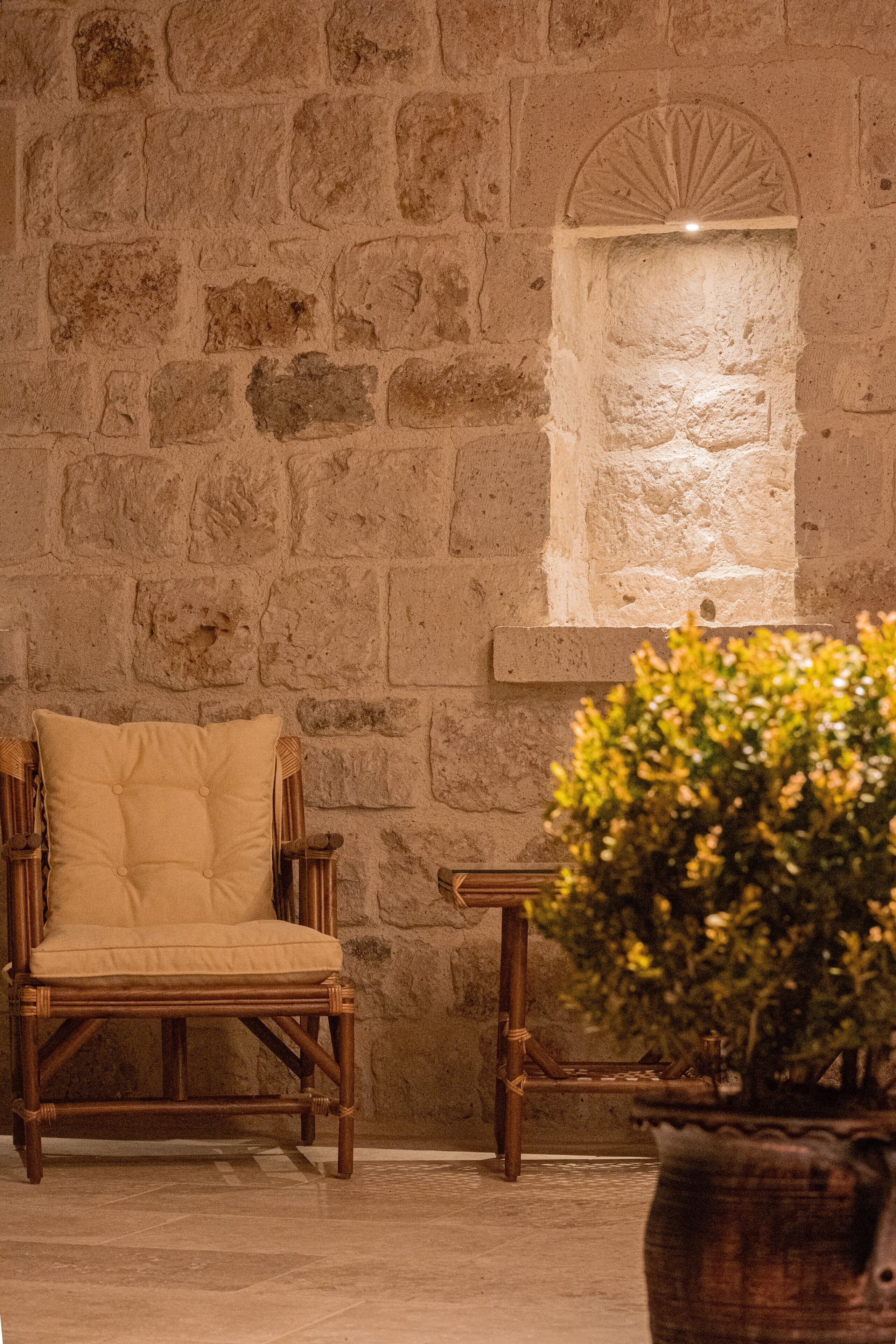 A stone wall with a built-in bench and a small window.