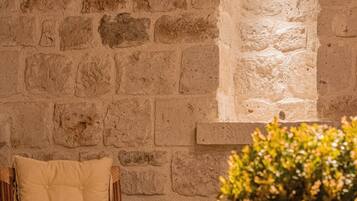 A stone wall with a built-in bench and a small window.