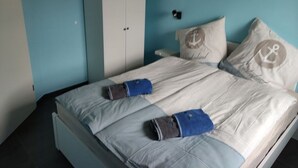 A bedroom with a bed, a wardrobe, and a nightstand. - Dat Ankerhuus Timmel (Grosefehn)