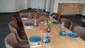 A dining area with a long wooden table set for six, surrounded by upholstered chairs. - Dat Ankerhuus Timmel (Grosefehn)