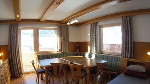 Une pièce chaleureuse avec une table à manger en bois, des chaises, un canapé et un lit.