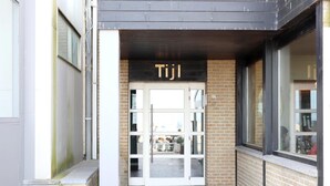 A building entrance with a sign reading "Tijl" above a glass door. - Attic Apartment Nieuwpoort With Coastal Views (Nieuwpoort)