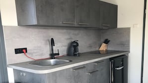 Una cocina moderna con lavavajillas integrado, cafetera y un bloque de cuchillos en la encimera.