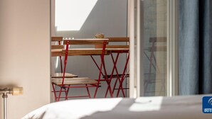 A room with a bed, a wooden chair, and a red metal chair. - Villa Modern Duplex Apartment (De Haan)