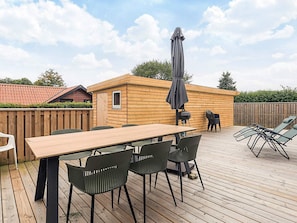 A wooden deck with a table and chairs, a barbecue grill, and an umbrella. - 5 Person Holiday Home in Karrebaeksminde (Karrebæksminde)