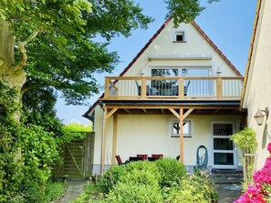 A two-story house with a balcony, a front door, and a small window. - Cuddly Shell Modern Retreat (Scharbeutz)