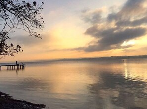 Un lac paisible, avec une jetée qui s’avance sur l’eau.