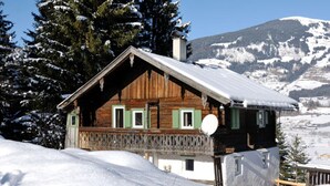 A wooden cabin with a balcony, surrounded by snow-covered mountains and trees. - Farmhouse in Hollersbach Near Kitzski (Hollersbach im Pinzgau)