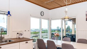 Una cocina moderna con un amplio ventanal, un comedor con sillas y vistas al exterior.