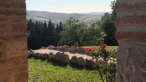 Un arc en pierre mène à un jardin d’où l’on peut admirer des collines ondoyantes.
