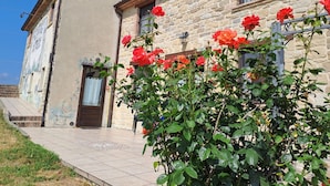 A stone building with a tiled entrance and a mural on the wall. - Terrace Retreat in the Marche (Pennabilli)