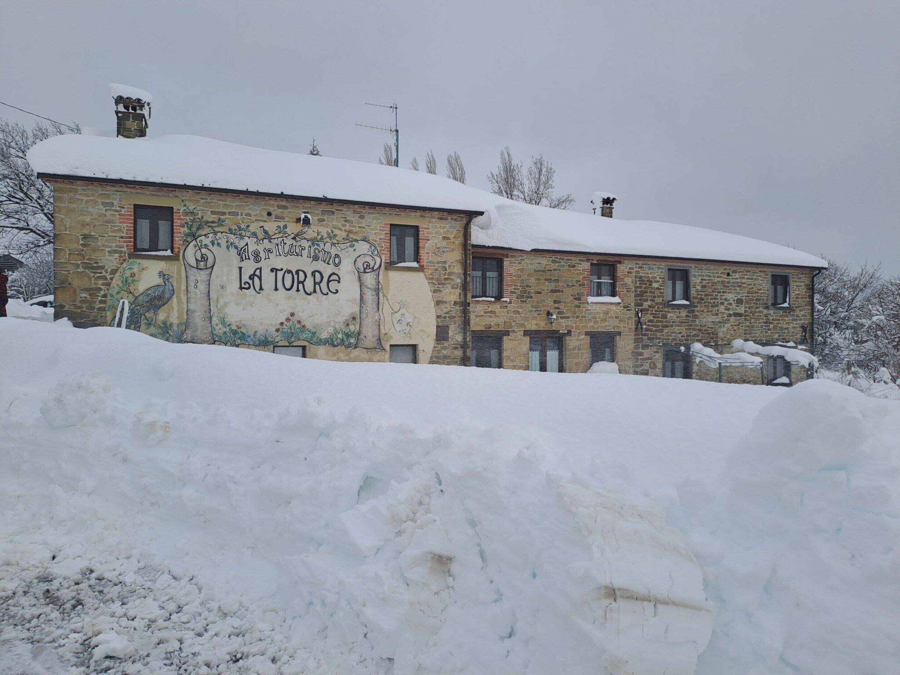 Un bâtiment en pierre sur lequel on peut lire l’inscription : « Agriturismo La Torre ».