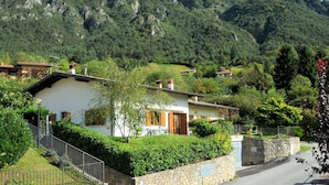Ein Bergdorf mit traditionellen Häusern, Steinmauern und üppigem Grün.