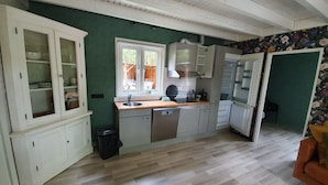 A kitchen with a window, wooden cabinets, a sink, and a refrigerator. - Holiday Home in Schoonloo With Balcony/terrace (Schoonloo)