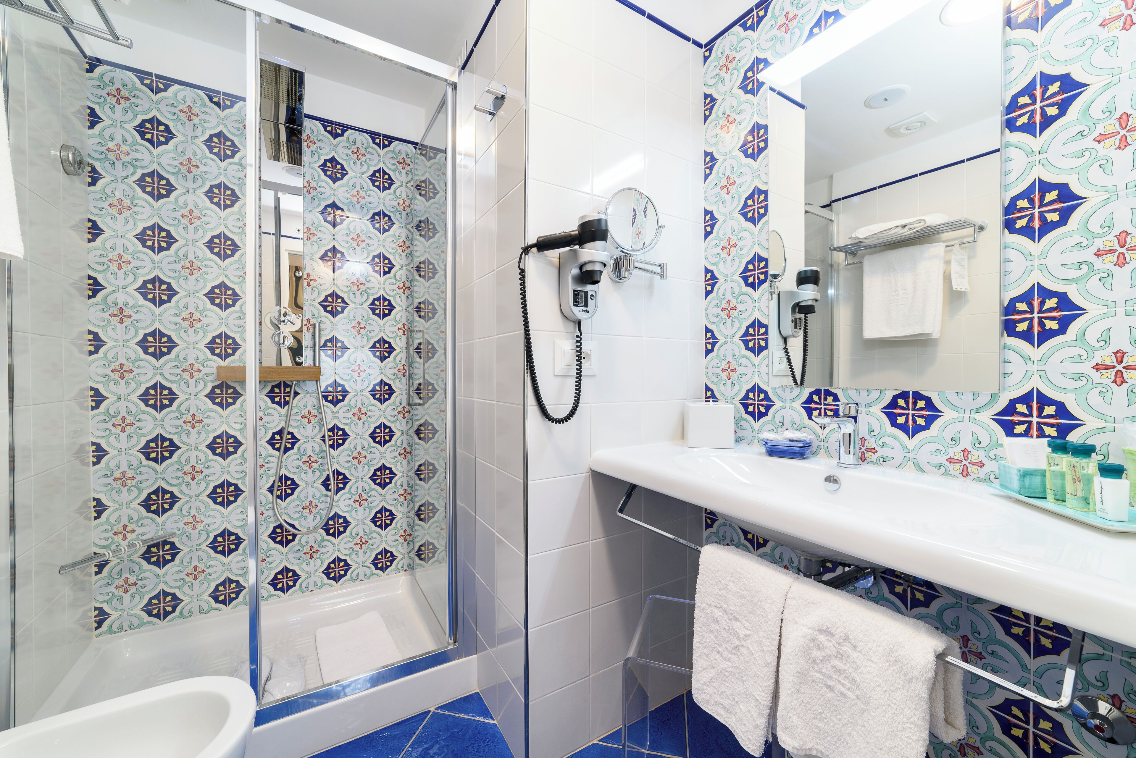 A bathroom with a shower, a sink, and a mirror.