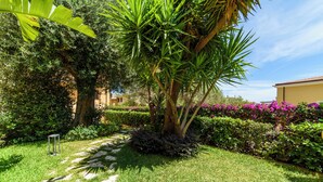 A well-maintained garden with a stone pathway, lush greenery, and flowering plants. - La Casa di Paolo Boutique Hotel (Camerota)