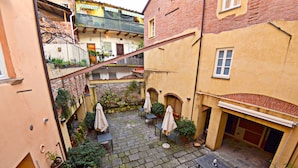 A courtyard with stone paving, outdoor seating, and potted plants. - Apartment in Lucca Near Amphitheater Square (Lucca)