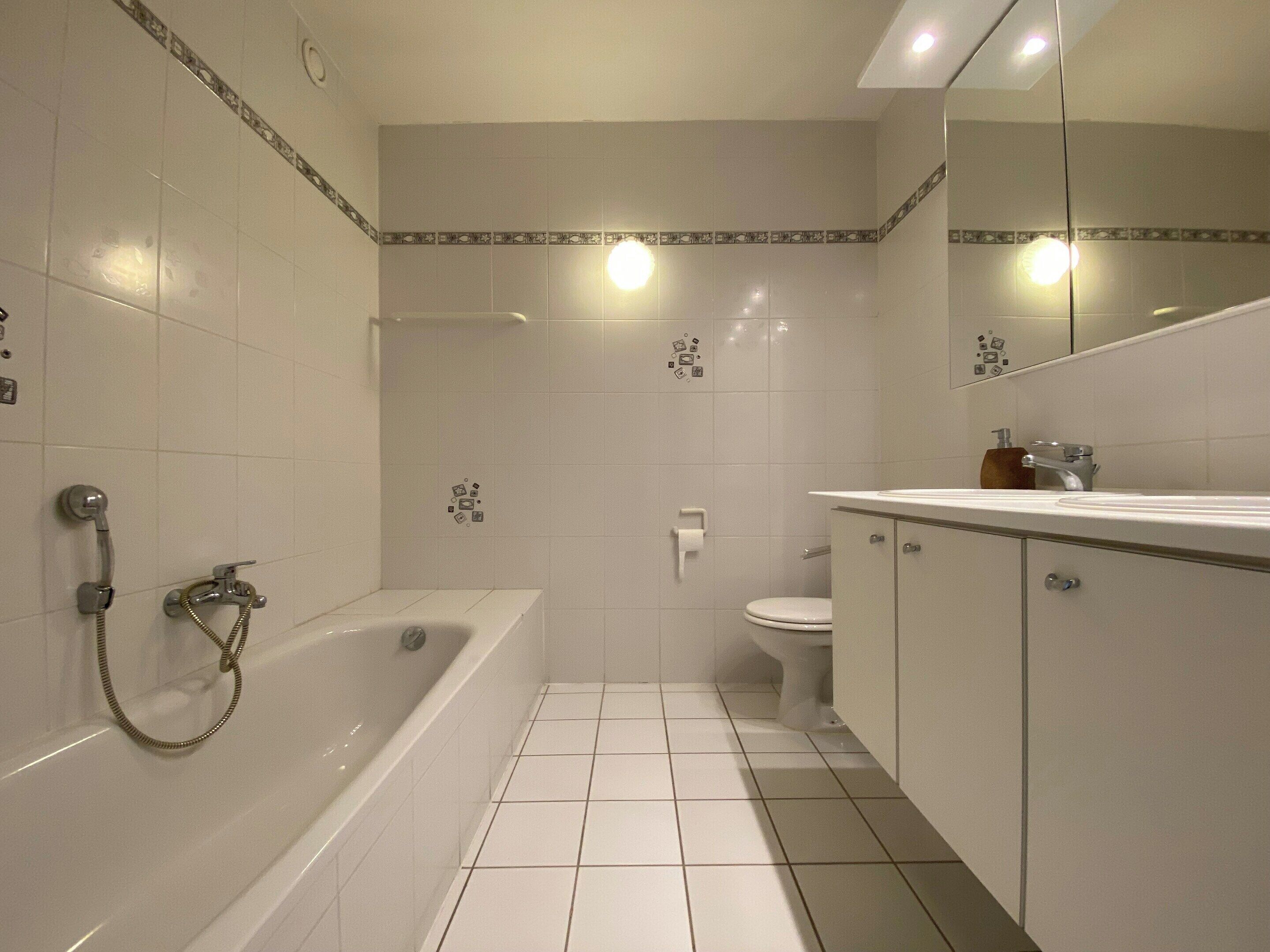 A bathroom with a bathtub, toilet, and sink.