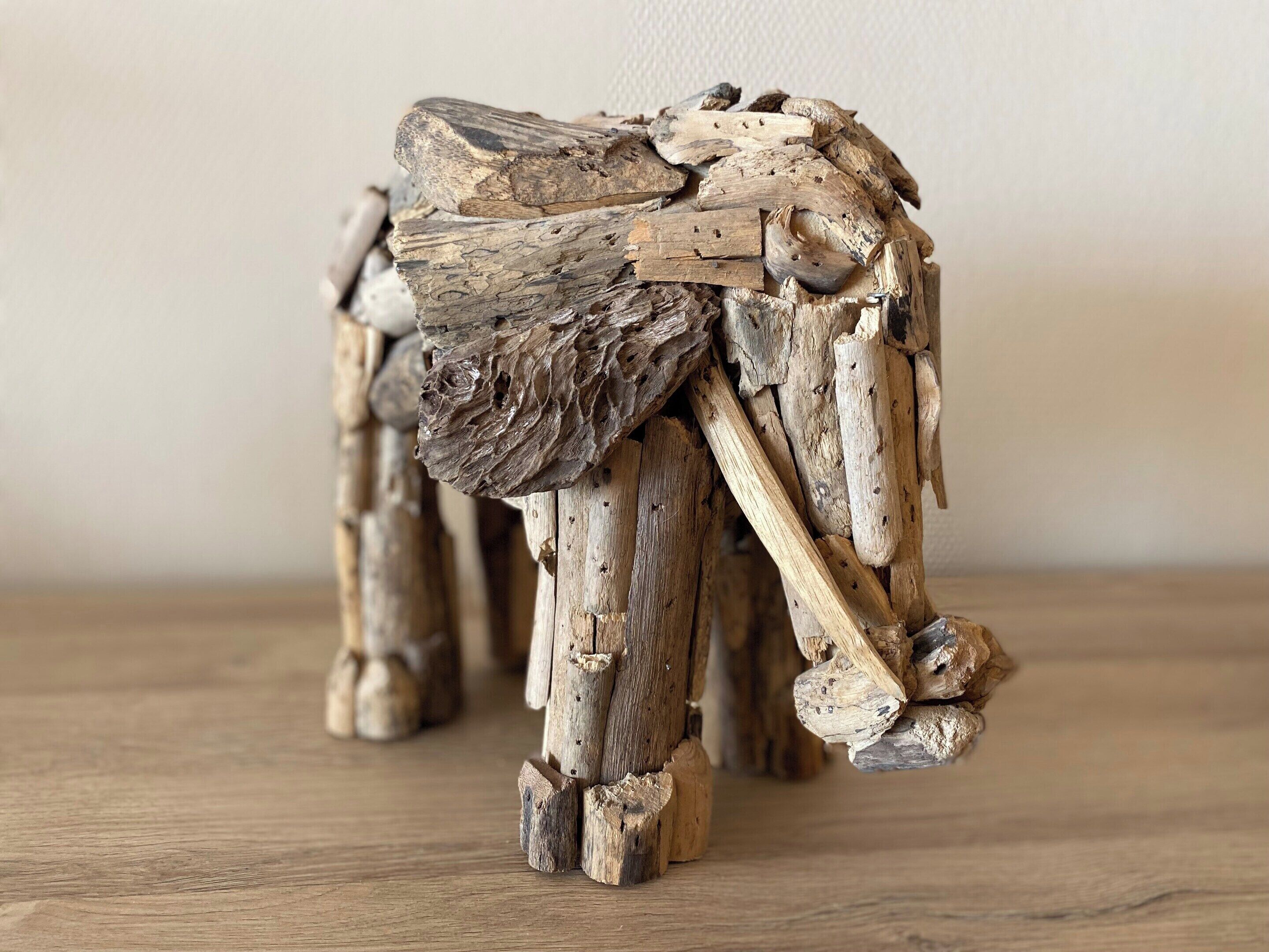 A wooden sculpture resembling an elephant, with a textured surface and a rough, unfinished appearance.
