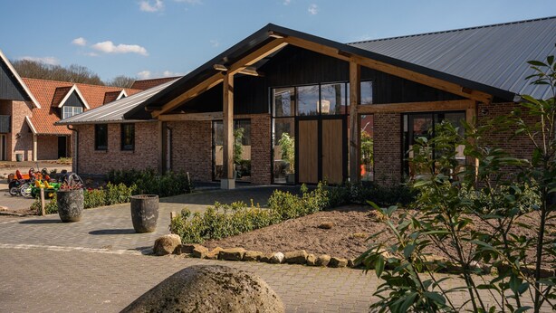 A modern building with a brick facade, large windows, and a sloped roof. - Beautiful Holiday Home With hot tub (Losser)