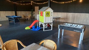 A play area with a foosball table, a playhouse, and a slide. - Beautiful Holiday Home With hot tub (Losser)