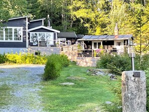 A cabin with a porch, a garage, and a small deck. - 4 Star Holiday Home in Vintrosa (Vintrosa)