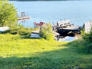 A dock with a boat, grassy area, and calm water. - 4 Star Holiday Home in Vintrosa (Vintrosa)