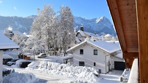 Un pueblo nevado con casas tradicionales y una montaña al fondo.