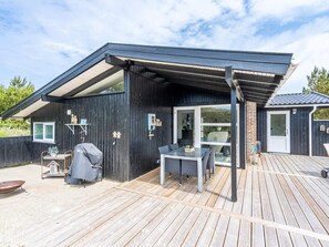 A modern outdoor deck with a covered seating area and a barbecue grill. - 4 Star Holiday Home in Henne (Henne)