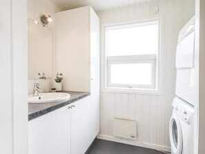 A bathroom with a white sink, mirror, and a window. - 4 Star Holiday Home in Henne (Henne)