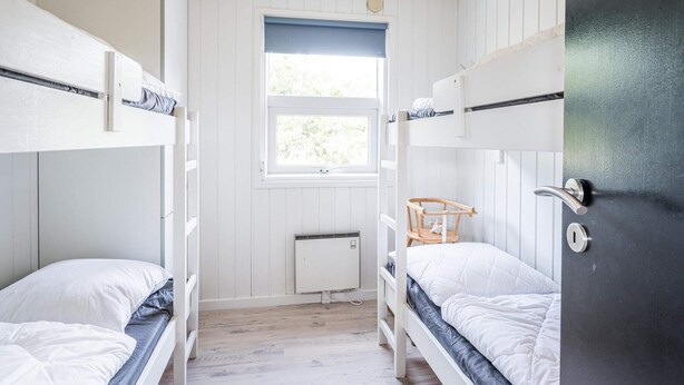 A bunk bed room with white walls, a window, and a radiator. - 4 Star Holiday Home in Henne (Henne)