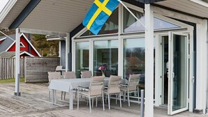 Een modern gebouw met een overdekte patio, compleet met een tafel en stoelen.