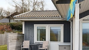 Een gebouw met een pannendak, twee ramen en een vlag.