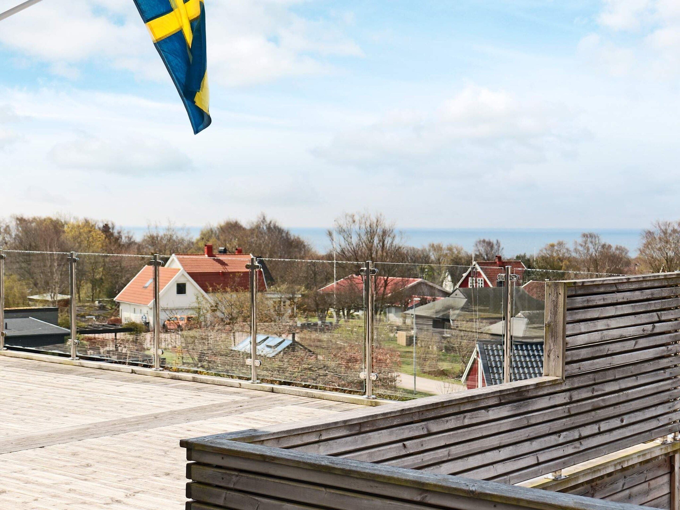 A wooden deck with a view of houses and a flag.