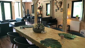 Un interior de madera con una mesa de comedor, sillas, sofás y una chimenea.